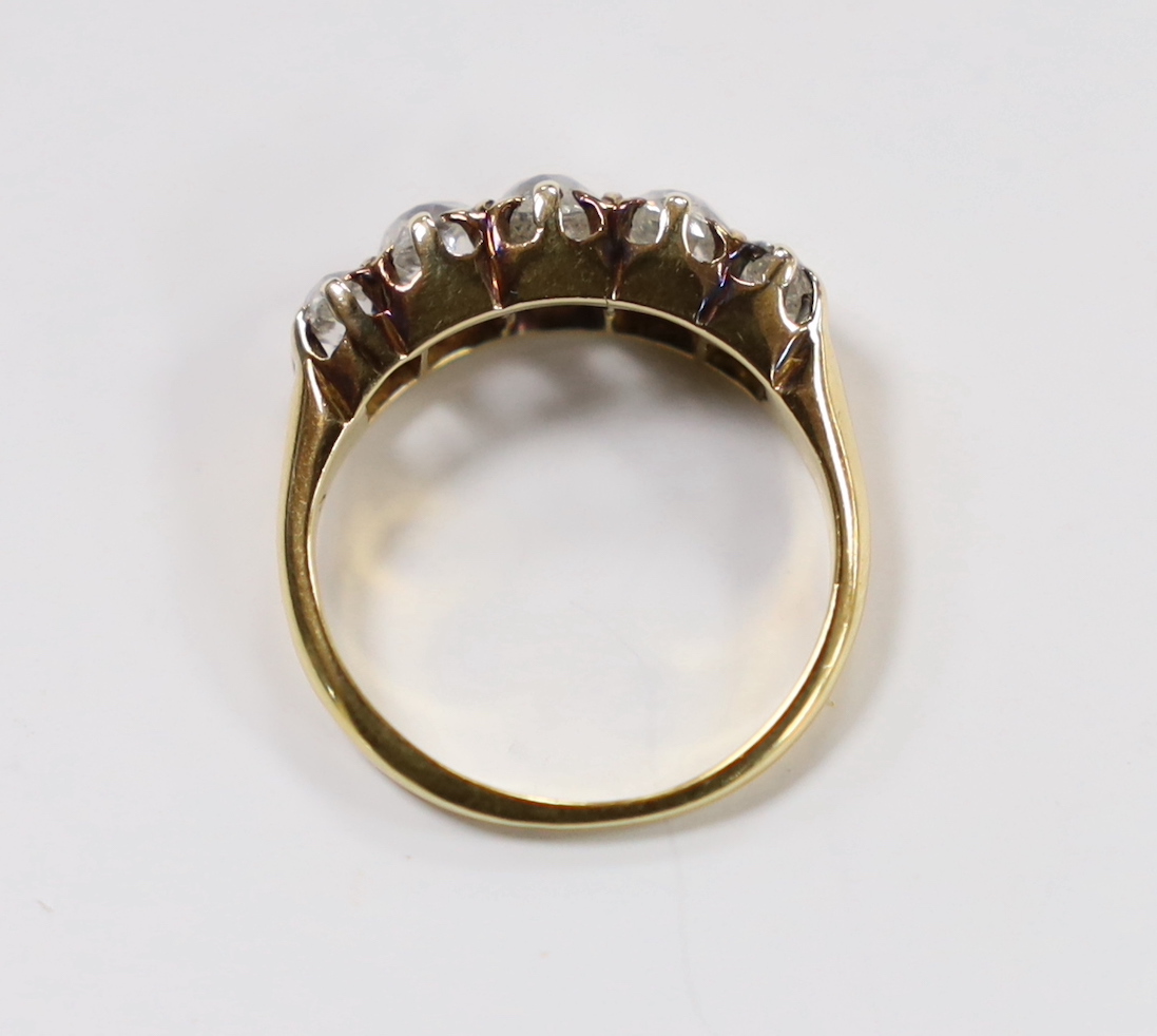 A yellow metal and graduated five stone diamond set half hoop ring, size J, gross weight 3.5 grams (a.f.).